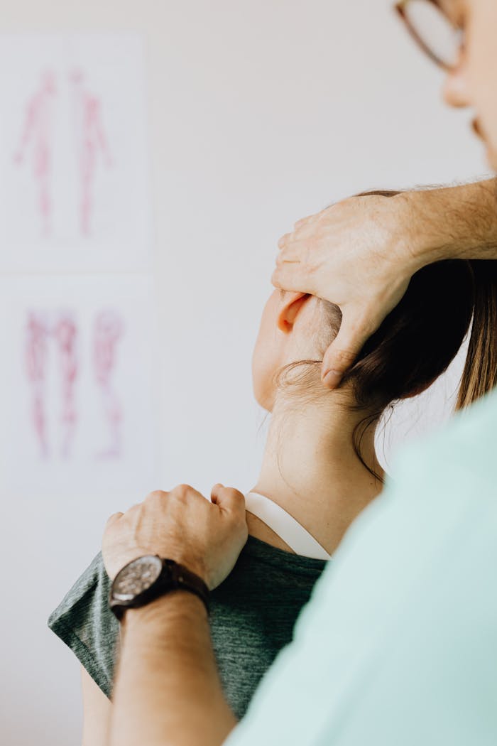 A female patient receives a chiropractic neck adjustment in a medical office for pain relief.